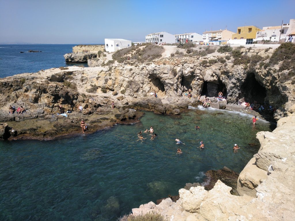 Vista desde arriba de la Cala Cova del Llop Marí donde se puede ver a la gente haciendo snorkel.